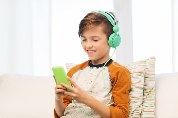 happy boy with smartphone and headphones at home - Foto, imagen