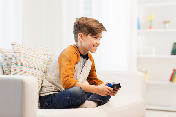 happy boy with joystick playing video game at home - Foto, Imagen