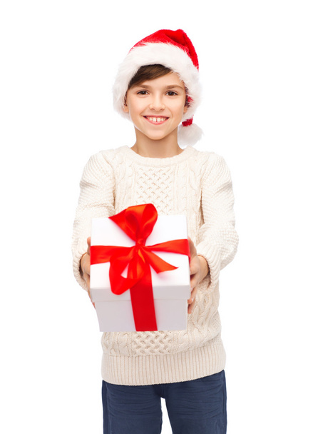 smiling happy boy in santa hat with gift box - Fotó, kép