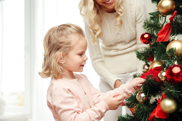 happy family decorating christmas tree at home - Фото, изображение