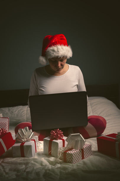 Lonely woman browsing internet on Christmas eve - Фото, изображение