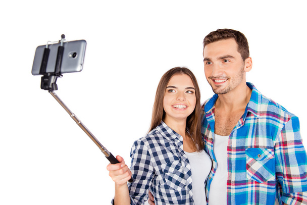 Cheerful couple in love making selfie photo with selfie stick - Foto, afbeelding