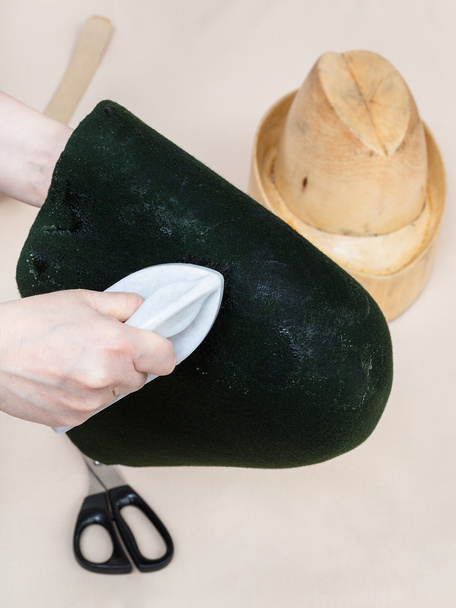 Chapeleiro colando um capuz de feltro para moldar no manequim
 - Foto, Imagem
