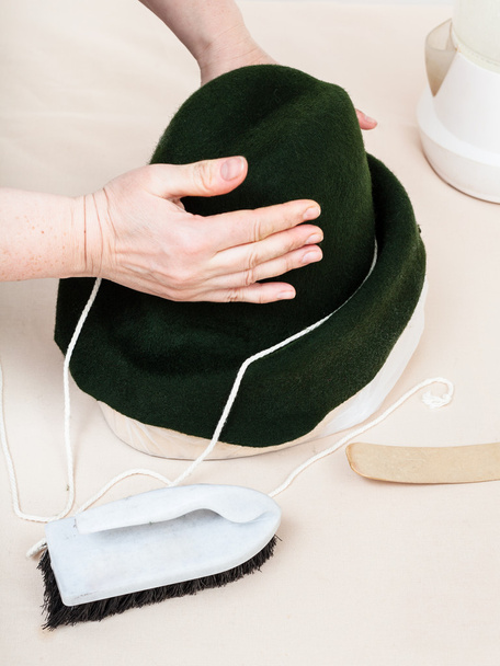 sombrerero fija una capucha de fieltro en maniquí para dar forma
 - Foto, Imagen