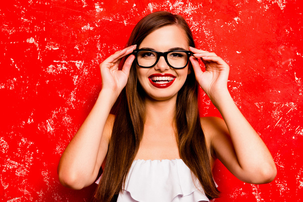 Pretty young cheerful girl holding glasses against the red backg - Fotografie, Obrázek