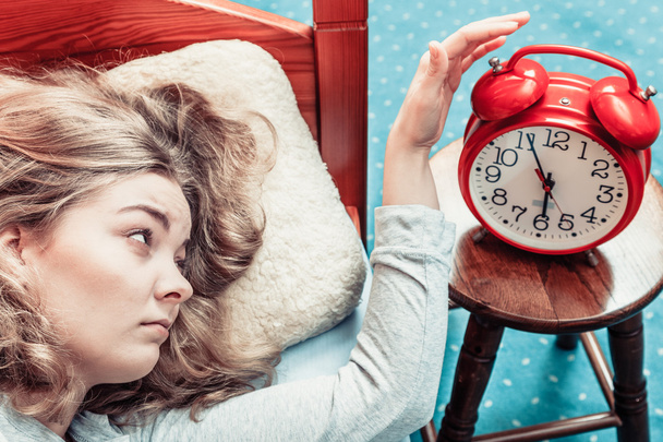Woman waking up turning off alarm clock in morning - Foto, Imagen