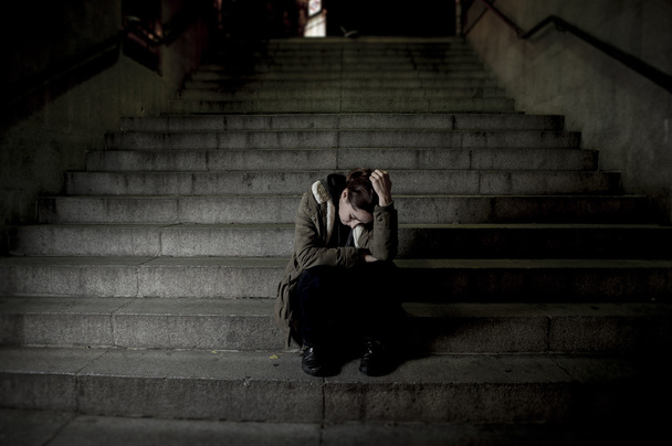 Traurige Frau allein auf der U-Bahn-Treppe, die unter Depressionen leidet und krank und hilflos wirkt - Foto, Bild