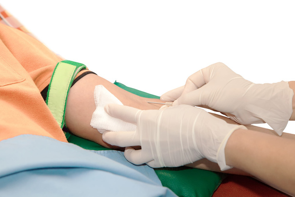 Doação de sangue, enfermeira perfura a veia do braço doador de sangue com tubo em branco agulha., Isolado em branco
 - Foto, Imagem