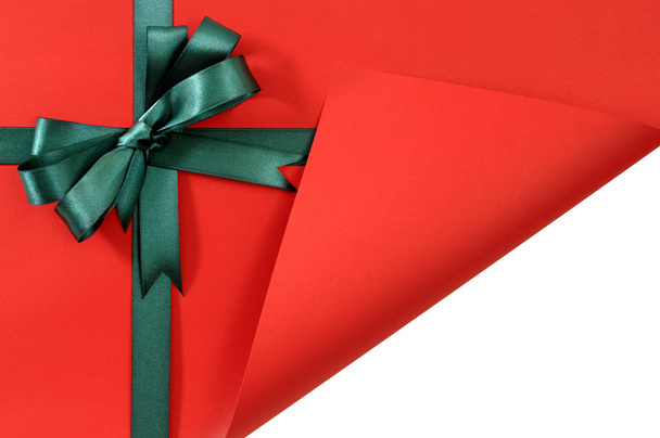 Fiocco nastro regalo verde su carta semplice sfondo rosso, piega angolo
 - Foto, immagini
