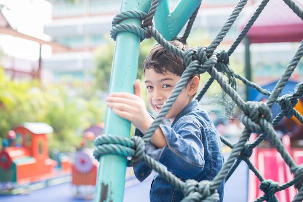 Mały chłopiec, wspinaczka na liny o plac zabaw dla dzieci - Zdjęcie, obraz