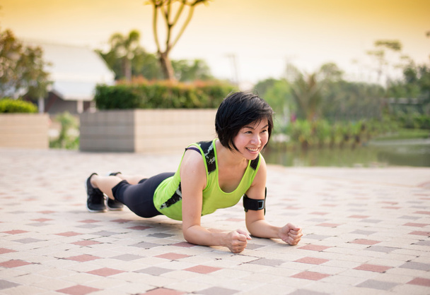 Asiatico donna lavoro fuori planking in il parco
 - Foto, immagini