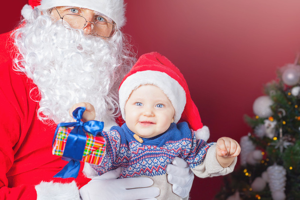 Bebê feliz e Papai Noel com presente, caixa de presente
 - Foto, Imagem