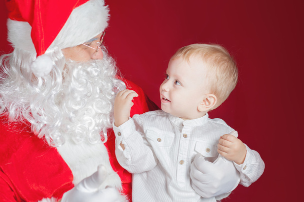 Little boy and Santa Claus at Christmas holiday - Foto, imagen