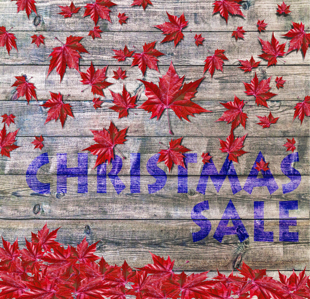 Christmas sale and red falling leaves laying on wooden background - Photo, Image