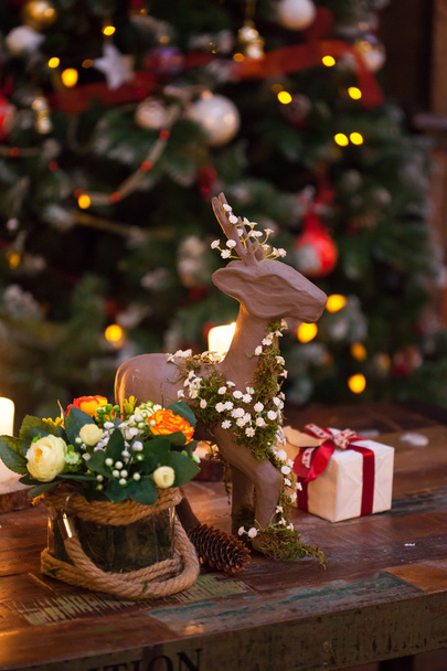 Christmas composition with figure of deer decorated for new year on dark wooden background. Festive mood - Fotó, kép
