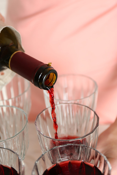 Nainen kaataa viiniä lasiin, lähikuva
 - Valokuva, kuva