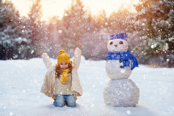 girl playing with a snowman - Photo, Image