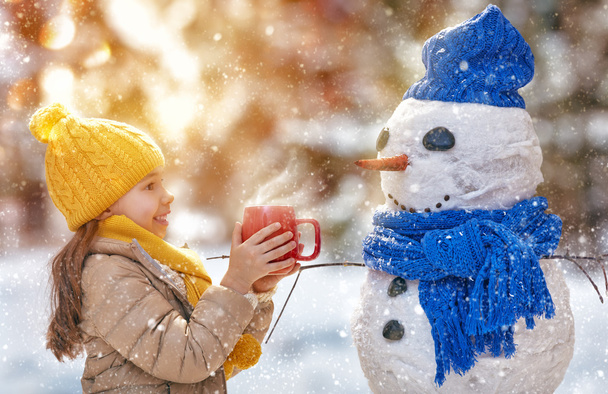 girl playing with a snowman - Photo, image