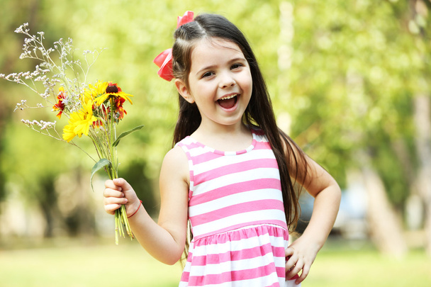 Happy little girl with flowers - Foto, Bild
