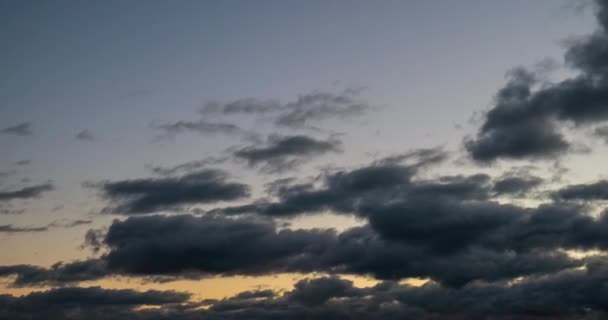 Kara bulutlar gökyüzü kaplı. Karanlık geliyor. Bulutlar günbatımı doğru uçuyor. 4k - Video, Çekim