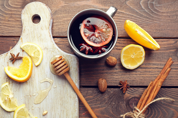 Composition of mulled wine, cinnamon and citrus on wooden background - 写真・画像