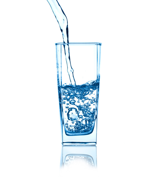 puring voda na sklenici na bílém pozadí - Fotografie, Obrázek