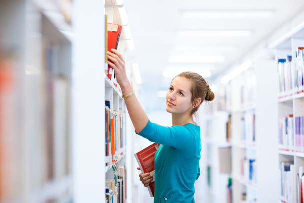 Female college student in a library - 写真・画像