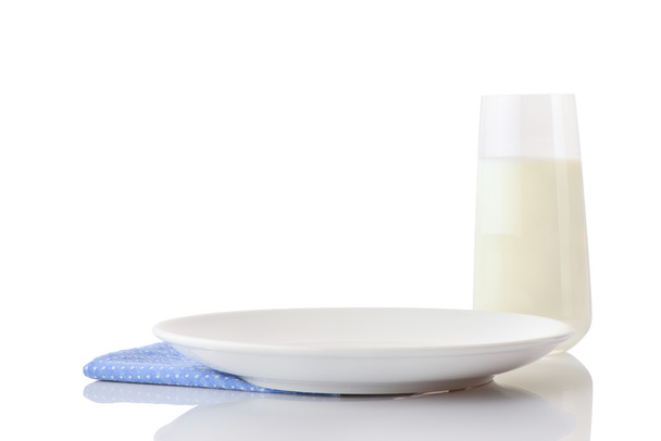 White ceramic plate on blue napkin in small white polka dots and glass of milk - Foto, Imagen