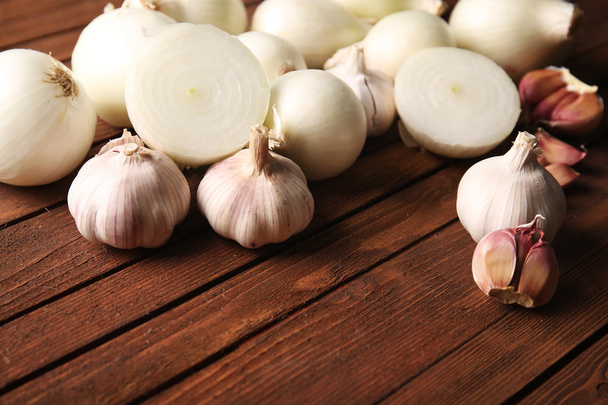 Fresh whole peeled onions with garlic on wooden background - Foto, imagen