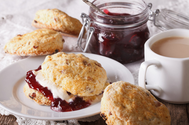Delicious English scones with jam and tea with milk close-up. Ho - Fotó, kép