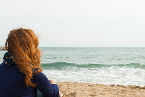 Κοκκινομάλλα κοπέλα σε μια παραλία της Βαρκελώνης άμμου, κοιτάζοντας τη θάλασσα - Φωτογραφία, εικόνα