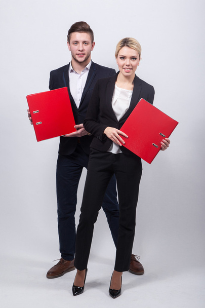 dos hombres de negocios el hombre y la mujer con carpetas de oficina rojas en una w
 - Foto, Imagen