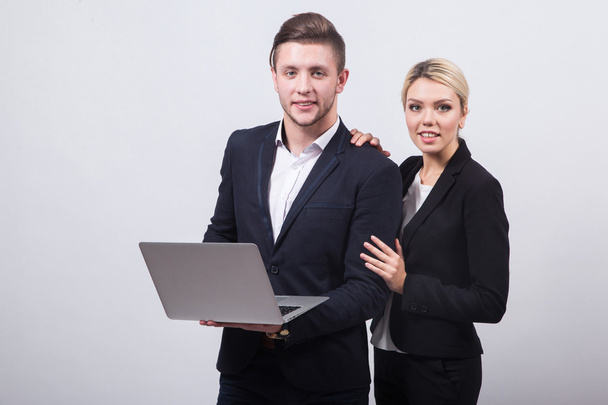 due uomini d'affari l'uomo e la donna con un computer portatile in mano su un whi
 - Foto, immagini
