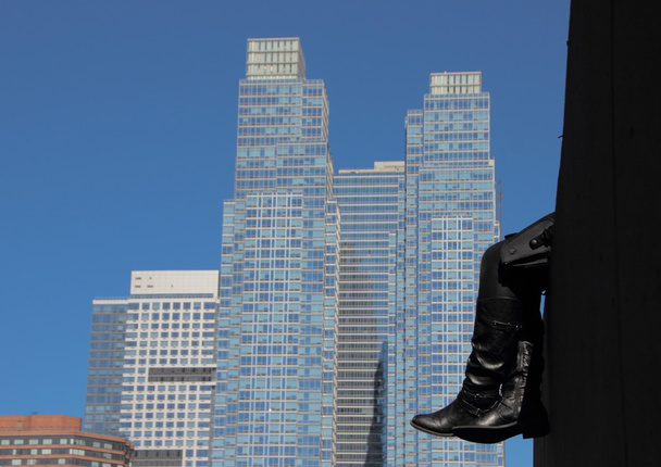 Rust zwart lederen laarzen met wolkenkrabber achtergrond - Foto, afbeelding
