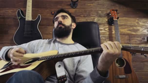 Красивый бородатый мужчина играет на акустической гитаре замедленной съемки
 - Кадры, видео