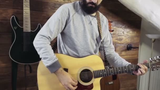 όμορφος γενειοφόρος άνδρας παίζει ακουστική κιθάρα την αργή κίνηση - Πλάνα, βίντεο