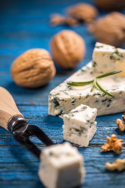 Blue cheese on blue wooden background - Фото, зображення