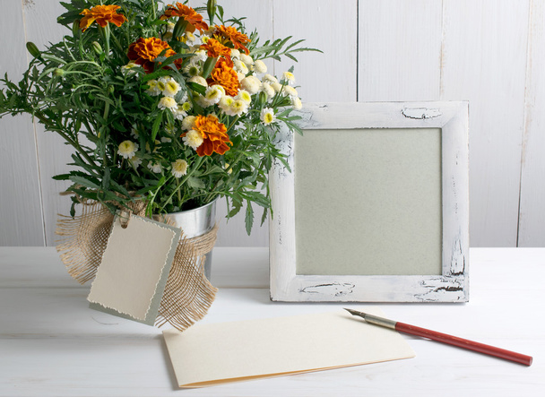 Retro photo frame and old pen with sheet paper and tagetes bouqu - Фото, зображення