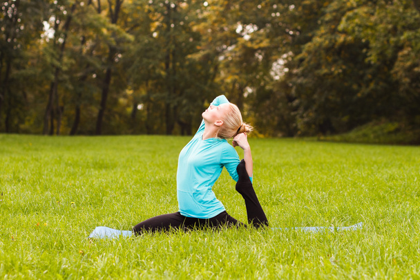 Woman practicing yoga in park - Fotoğraf, Görsel