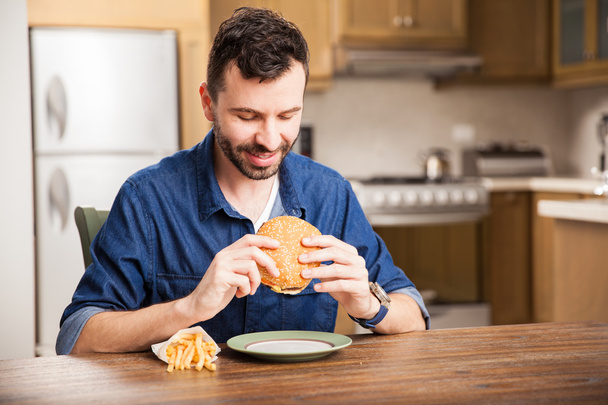 man eten van een hamburger - Foto, afbeelding