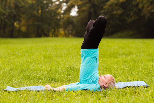 Woman practicing yoga in park - Фото, зображення