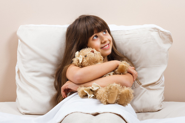 ayı oyuncak ile yatakta kız - Fotoğraf, Görsel