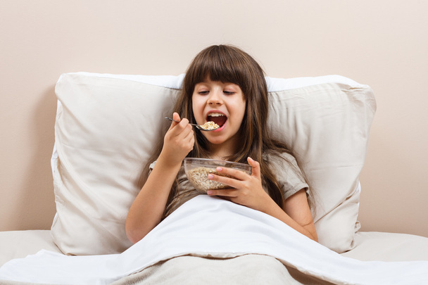 girl in bed eating breakfast - Фото, изображение