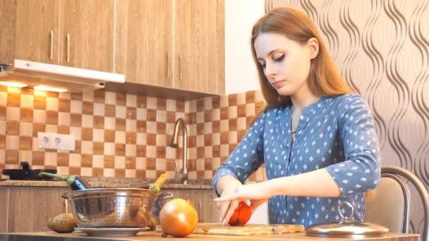Životní styl v zdravých potravinách: krásná žena, která příležitostně vaří, v kuchyni krájí zeleninu. Střední záběr, přenosný, pomalý pohyb 60 fps. - Záběry, video