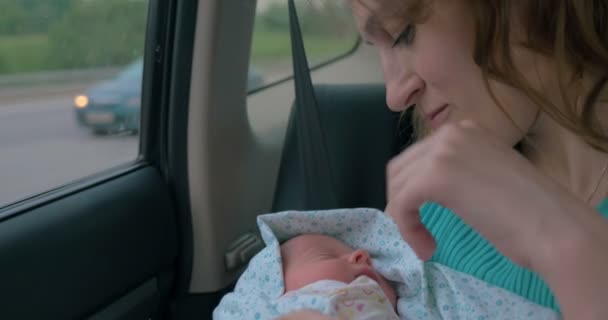 Kobieta z dzieckiem w ramionach jazda samochodem - Materiał filmowy, wideo