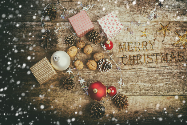 Festive Gifts with Boxes, Baubles, Pine Cones, Walnuts on Wooden Background. - Foto, imagen