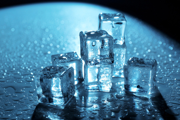 Melting ice cubes under blue light with drops around, close up - Fotoğraf, Görsel