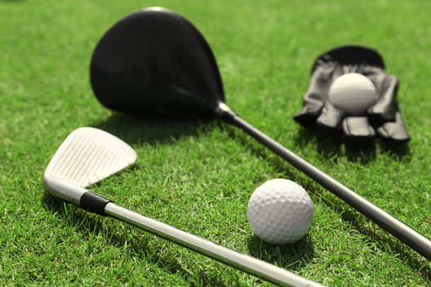Golf clubs with ball and black glov - 写真・画像