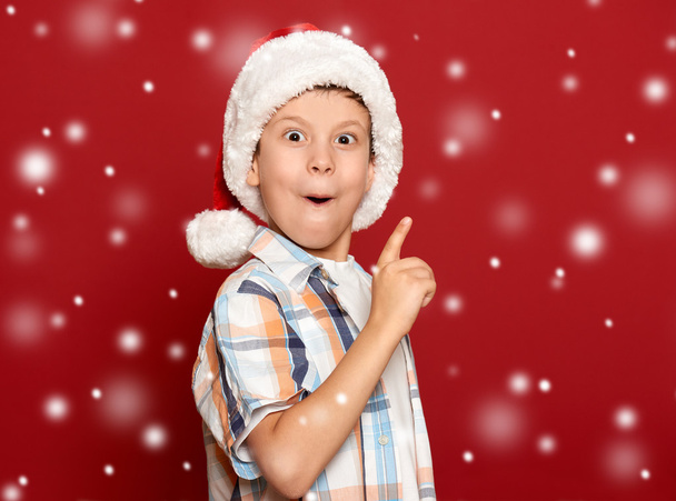 Winterurlaub Weihnachtskonzept - Junge mit Weihnachtsmütze haben Idee auf - Foto, Bild
