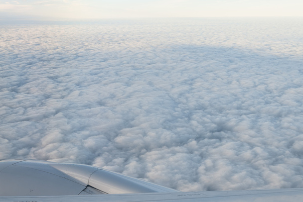 Felhők és ég a repülőgép ablakán keresztül - Fotó, kép